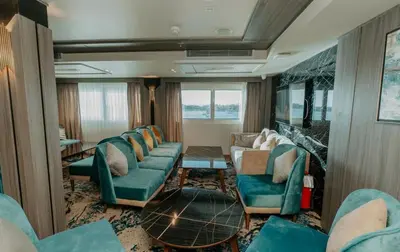 a living room with blue couches and a fireplace at Cleopatra Nile Cruise From Luxor 3&4 Nights Every Saturday and Monday, Thursday in Luxor