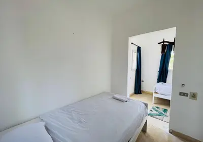 a white bedroom with a bed and a doorway at Unique 6 Bedrooms Villa 38 at White Villas El-Gouna in Hurghada
