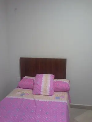 a bedroom with a pink bed with a wooden headboard at Princess resort unit number 260A Markos in Hurghada