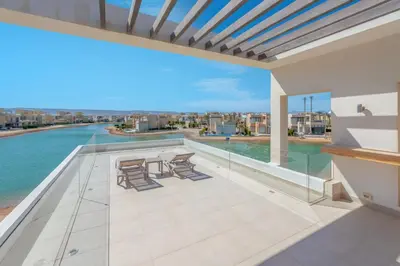 a balcony with chairs and a view of the water at Ascot Bay, Premium 5BR Lagoon Beach House & Pool in Tawila, El Gouna in Hurghada