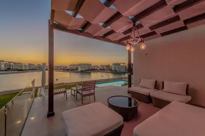 a patio with a view of the water and a pool at Ascot Bay, Premium 5BR Lagoon Beach House & Pool in Tawila, El Gouna in Hurghada