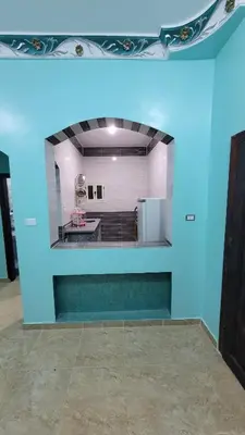 a blue wall in a room with a kitchen at Ahmed House in Safaga
