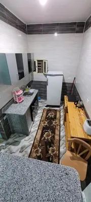 a kitchen with a counter and a refrigerator in a room at Ahmed House in Safaga