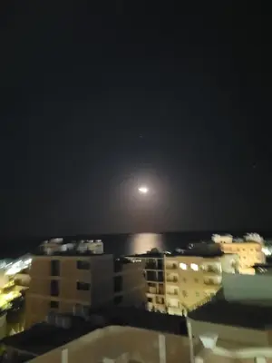 a view of the moon from a city at night at Ahmed House in Safaga