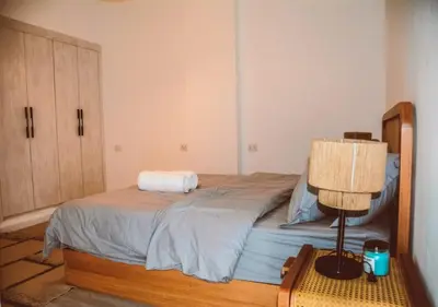 a bedroom with a bed with a lamp and a dresser at Peaceful Villa 3BR at Sholan with Private Heated Pool in Hurghada