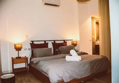 a bedroom with a bed with a towel animal on it at Peaceful Villa 3BR at Sholan with Private Heated Pool in Hurghada