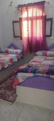a bedroom with two beds and a window at Abo Tamem Guest House in Aswan
