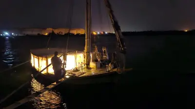a man standing on a sail boat at night at Abo Tamem Guest House in Aswan