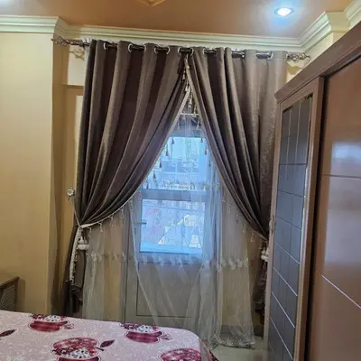 a room with a table and a window with curtains at Susan's Guest House and Tours in Luxor