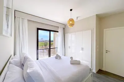 a bedroom with a large white bed and a window at Homelike & Sunny 1 BDR Cyan El Gouna in Hurghada