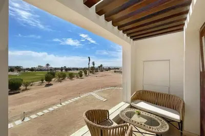 a balcony with a table and chairs and a view of the desert at Homelike & Sunny 1 BDR Cyan El Gouna in Hurghada