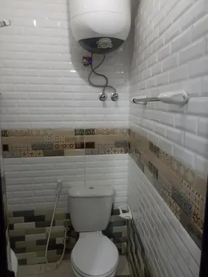 a bathroom with a toilet and a light on the wall at NUBIAN MONALIZA guest house in Aswan