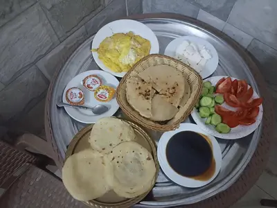 a plate of food with eggs bread and tomatoes at NUBIAN MONALIZA guest house in Aswan