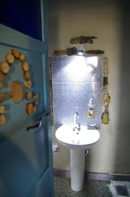 a bathroom with a white sink and a blue door at Bedouin Lodge Luxor in Luxor