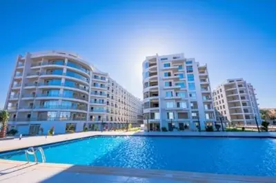 a swimming pool in front of two tall buildings at Happy Home in Hurghada