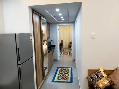 a hallway leading to a kitchen with a refrigerator at Happy Home in Hurghada