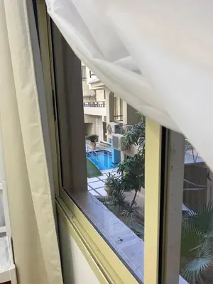 a window with a view of a swimming pool at Beautiful apartment near sea 1+1 Dream Beach in Hurghada