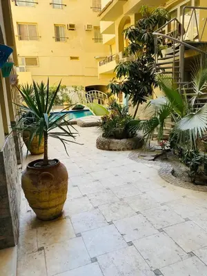 a courtyard with potted plants and a building at Beautiful apartment near sea 1+1 Dream Beach in Hurghada