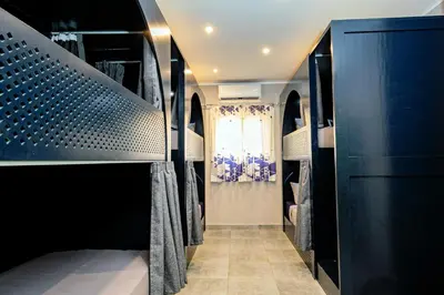 a walk in closet with black cabinets and a window at Bedcoin Hostel in Hurghada