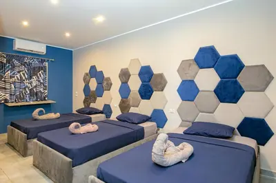 three beds in a room with blue and white at Bedcoin Hostel in Hurghada