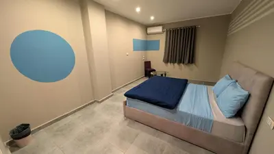 a bedroom with a bed and a couch in a room at Bedcoin Hostel in Hurghada