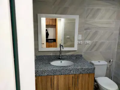 a bathroom with a sink and a toilet and a mirror at شقة احلامك على البحر in Hurghada