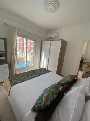 a bedroom with two beds and a window at 1 Bed Apartment - Balcony Pool Parking in Hurghada