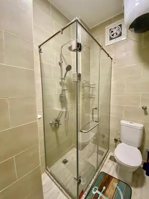 a shower stall in a bathroom with a toilet at 1 Bed Apartment - Balcony Pool Parking in Hurghada