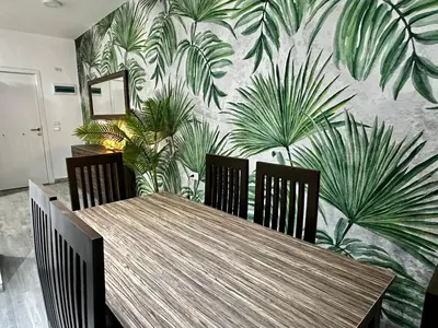 a dining room table with chairs and a mural of plants at Hurghada - Apartment - Sleeps 6 - Pool - Parking in Hurghada