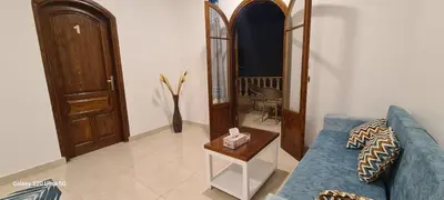 a living room with a blue couch and a table at Moon fourteen in Luxor
