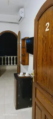 a room with a door with a table and a stove at Moon fourteen in Luxor