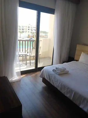 a bedroom with a bed and a view of a balcony at Nayah Stays, Luxurious bedroom in Fanadir Marina in Hurghada