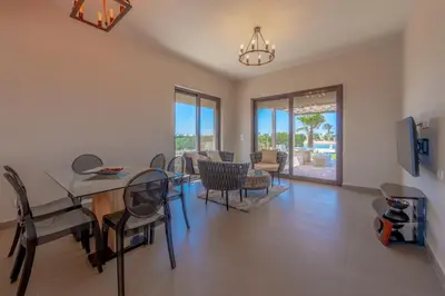 a dining room and living room with a table and chairs at NEW! Gouna, Cyan Cozy 3BR Townhouse Lagoon & Pool in Hurghada
