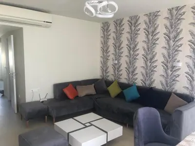 a living room with a black couch with colorful pillows at Penthouse in Hurghada