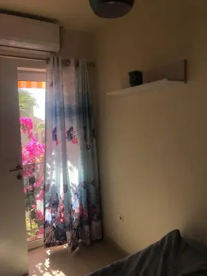 a room with a window with a curtain and a door at Penthouse in Hurghada