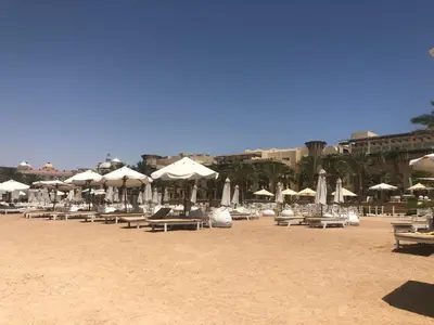 a group of chairs and umbrellas on a beach at Penthouse in Hurghada