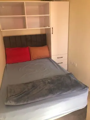 a bedroom with a bed with an orange pillow at Penthouse in Hurghada