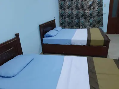 two beds in a room with blue lights at Nile Roof Hotel& Restaurant in Luxor