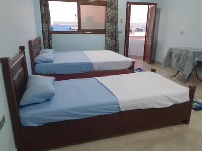 two beds in a room with a view of the ocean at Nile Roof Hotel& Restaurant in Luxor