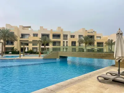a pool in front of a hotel with an umbrella at Mangrove m3-1b-02 in Hurghada