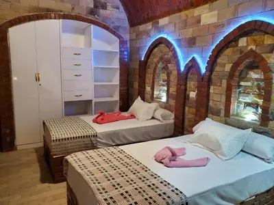 two beds in a room with arches at Laila Flat in Al Aqālitah