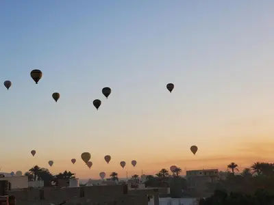 a group of hot air balloons flying in the sky at Laila Flat in Al Aqālitah