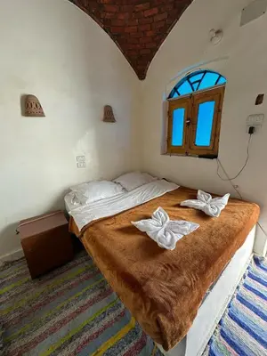 a bedroom with a bed with two white bows at Nubian King in Aswan