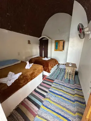 a hotel room with two beds and a colorful carpet at Nubian King in Aswan
