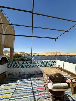 a patio with a table and a view of the water at Nubian King in Aswan