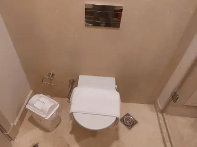 a small bathroom with a white toilet and a trash can at Mangroovy - 2BR La Blanca Pool View in Hurghada