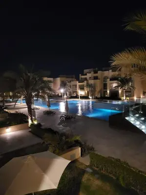 a night view of a swimming pool at a resort at Mangroovy - 2BR La Blanca Pool View in Hurghada