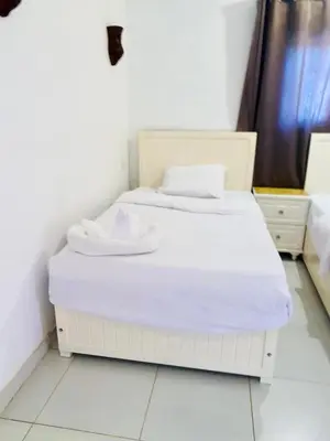 a white bed in a room with a white floor at Moon House of Luxor in Luxor