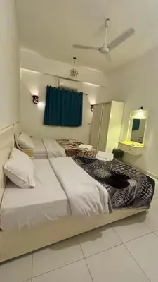a bedroom with two beds and a blue curtain at Moon House of Luxor in Luxor