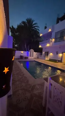 a swimming pool in front of a house at night at Moon House of Luxor in Luxor
